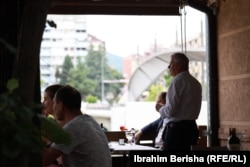 Kamerieri Agron Berisha duke u shërbyer të klientëve në restorantin “Ura”.