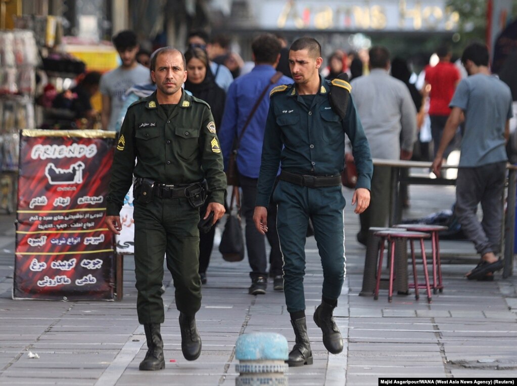 Dy policë ecin nëpër Teheran, më 16 korrik. Oficeri në të majtë është i veshur me uniformën standarde të gjelbër që vishet nga njësitë e policisë së &quot;moralit&quot;. &nbsp;