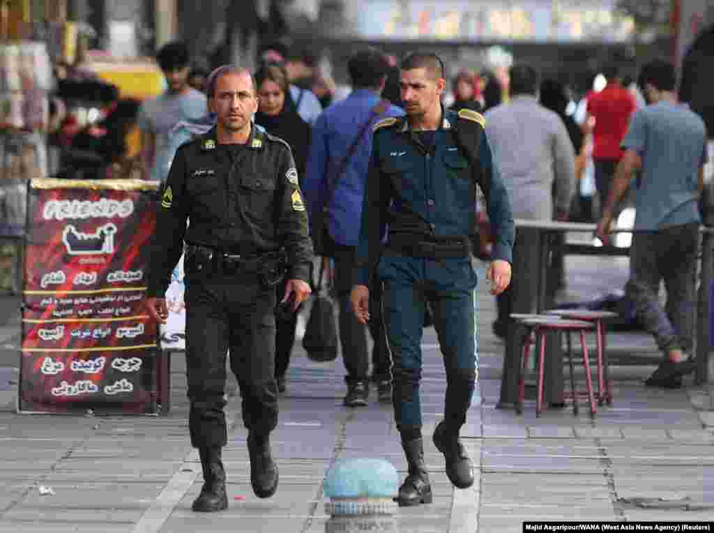 Policajci šetaju Teheranom 16. jula. Policajac s lijeve strane je odjeven u standardnu zelenu uniformu koju nose službenici policije za moral.