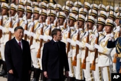 Президент Франции Эммануэль Макрон (справа) осматривает почетный караул вместе с президентом Китая Си Цзиньпином возле Дома народных собраний в Пекине, четверг, 6 апреля 2023 года