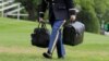 Vojni pomoćnik u Bijeloj kući nosi kofer i torbu u u kojoima se nalaze šifre za nuklearno oružje za vrijeme mandata predsjednika Bakacka Obame, maj 2016. 