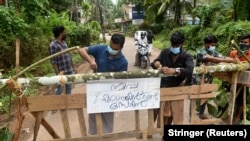 ინდოეთი, სოფლის მცხოვრებნი აწყობენ ბარიერს, რომელზეც მითითებულია, რომ ამ ბარიერს მიღმა არის "ნიპას" ვირუსით ინფიცირების ზონა. 2023 წელი, სექტემბერი