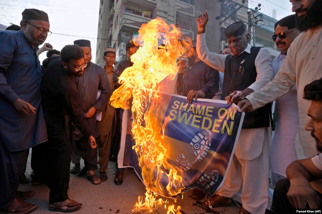 Aktivistët e Forumit të Myslimanëve të Bashkuar në Pakistan duke djegur një fotografi të flamurit suedez, gjatë një demonstrate në Karaçi, Pakistan.