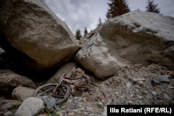 A child's broken bike lies amid the rubble.