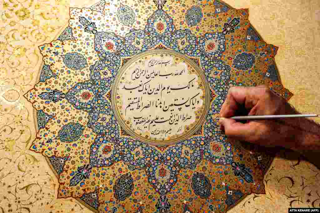  Mohammad Hossein Aghamiri, një artist i specializuar në miniaturat persiane, duke punuar në një nga pjesët e tij që përshkruan al-Fatihan, kapitullin e parë t Kuranit, në punëtorinë e tij në Teheran. &nbsp; 