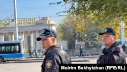 Полицейские на фоне главного входа в Центральный парк. Алматы, 25 октября 2023 года