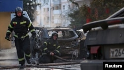 Rescue workers in Belgorod extinguish burning cars after what Russian authorities said was a Ukrainian military strike on the city on December 30. 