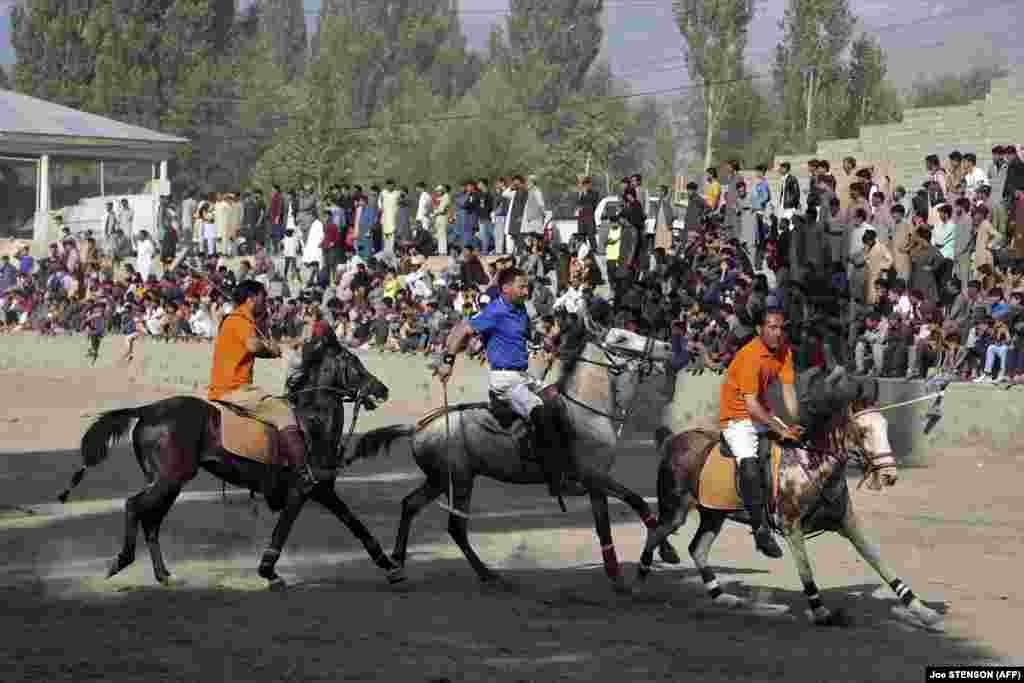 Polo players ride their horses as they compete during a match in Skardu, in Pakistan&#39;s northeastern Gilgit-Baltistan region.