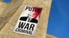 В Эстонии на границе с Россией повесили баннер "Путин — военный преступник"