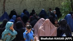 Femei afgane așteaptă ajutoarele alimentare distribuite de Crucea Roșie la periferia orașului Jalalabad, la 4 septembrie 2023.