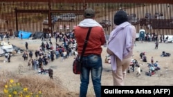 Migránsok várakoznak arra, hogy az amerikai hatóságok feldolgozzák adataikat a mexikói határon, Tijuanában május 10-én