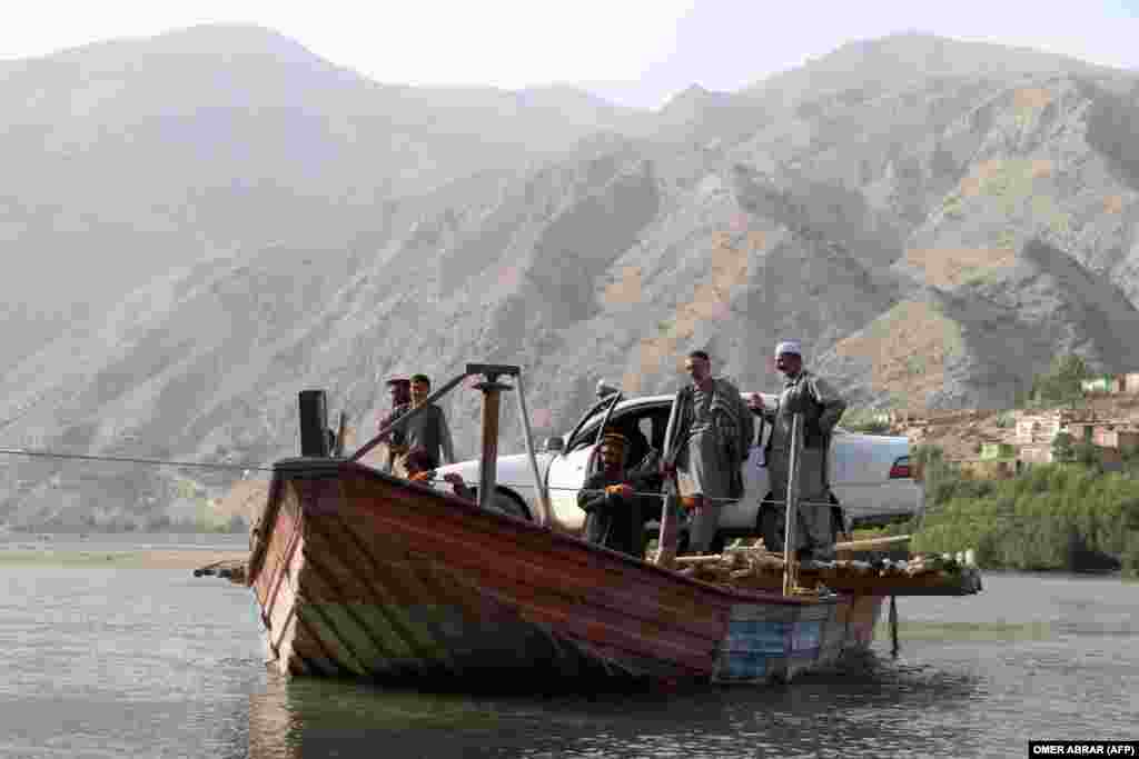 Afghan men use a boat to cross the Kokcha River on the outskirts of Fayzabad, Badakhshan Province.