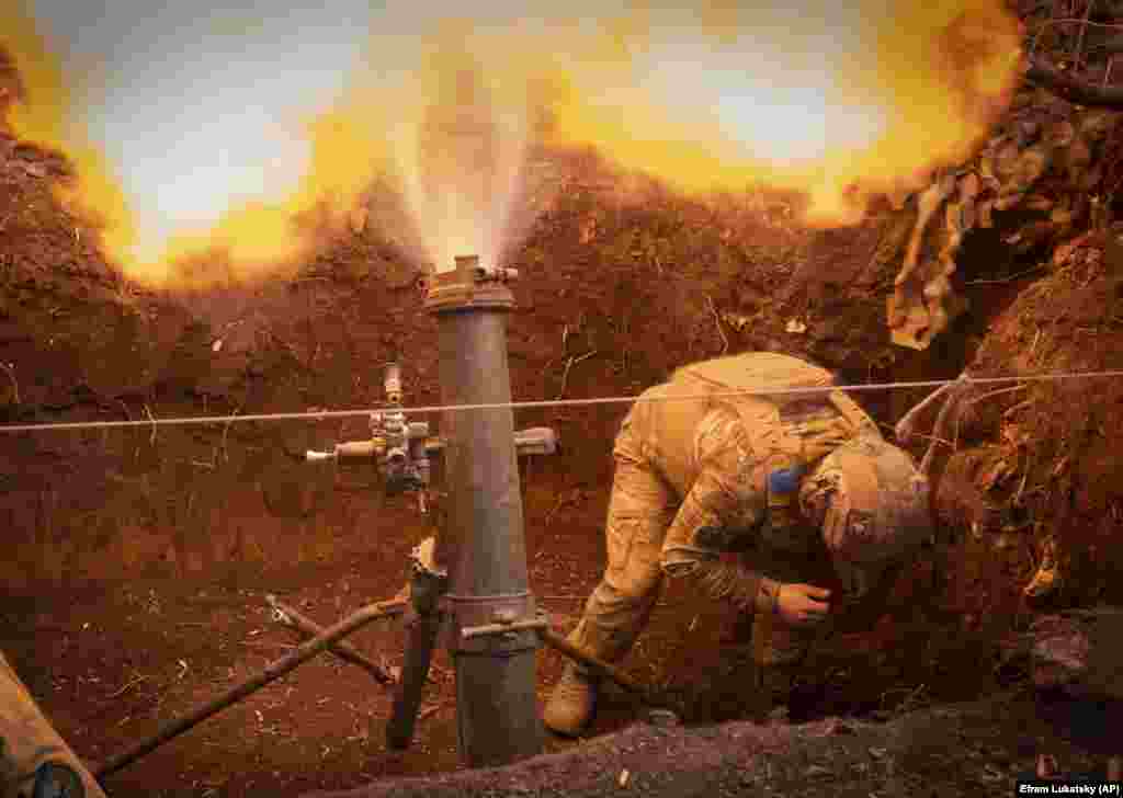 A Ukrainian soldier fires a 122 mm mortar toward Russian positions at the front line near Bakhmut.