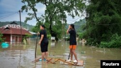 Žene pokušavaju stići do sigurnijeg mjesta nakon obilnih kiša uzrokovanih ciklonom Remal u Imphalu, Indija, 29. maja 2024.