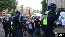  Полицаи се сблъскват с протестиращи по време на демонстрацията 