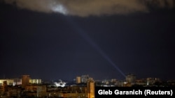 Ukrainian servicemen use a searchlight as they search for drones in the sky over the city during a Russian drone and missile strike, amid Russia’s attack on Ukraine, in Kyiv, Ukraine May 8, 2024