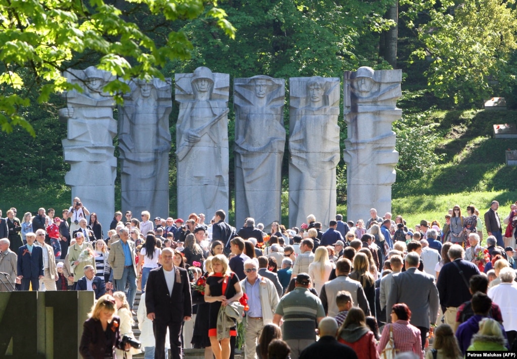 Një turmë e njerëzve e mbledhur pranë një memoriali për ushtarët sovjetikë në varrezat Antakalnis në Vilnius në maj 2013. Skulpturat u shkatërruan në dhjetor të vitit 2022 pasi një urdhër i mëparshëm i Komitetit të të Drejtave të Njeriut të OKB-së e kishte ndërprerë punën.