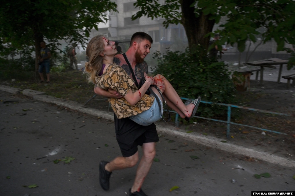 Një burrë duke mbajtur një grua të plagosur pas sulmeve ruse me raketa në qytetin Pokrovsk në Ukrainën lindore. Të paktën shtatë persona vdiqën në këtë sulm.