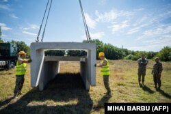 Soldați români construind un adăpost într-un sat din Delta Dunării după ce drone din ostilitățile din Ucraina vecină au început să ajungă și pe teritoriul românesc.