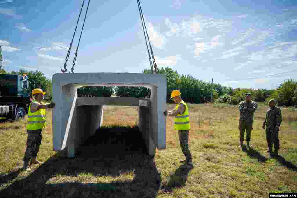 Soldați români încep construcția unui adăpost antiaerian pentru locuitorii din satul Plauru, în Delta Dunării, la aproximativ 300 de kilometri est de București, pe 12 septembrie. Ministerul român al Apărării a ordonat construirea structurilor după ce au fost găsite fragmente de drone în weekend.