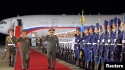 Russian Defense Minister Sergei Shoigu (center) is welcomed at an airport in Pyongyang on July 25. 