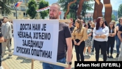 Na plakatu na skupu u Severnoj Mitrovici piše: "Dosta nam je čekanja, hoćemo zajednicu srpskih opština'.