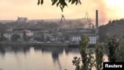 Füst száll fel a hajógyárból, amelyet állítólag ukrán rakétatámadás ért a Krímben, Szevasztopolban. 2023. szeptember 13.