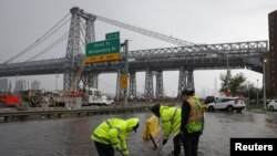 Radnici pokušavaju odblokirati začepljene odvode, New York, 29. septembra 2023.