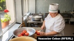 O bucătăreasă în proces de pregătire a prânzului la o grădiniță din Grătiești, martie 2023.