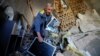 A man carries belongings inside a house heavily damaged by recent shelling in Donetsk, Russian-controlled Ukraine, on September 27.
