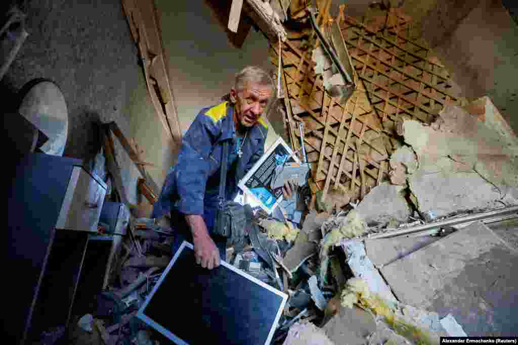 A man carries belongings inside a house heavily damaged by recent shelling in Donetsk, Russian-controlled Ukraine.