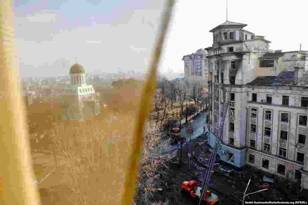 Viewed from an apartment whose windows were blown out, a ladder truck stands near a residential area that had earlier caught fire following a Russian missile attack in Kyiv on March 21. The first large Russian attack against the capital in recent weeks targeted the city with both ballistic and cruise missiles, according to Serhiy Popko, the head of its military administration.