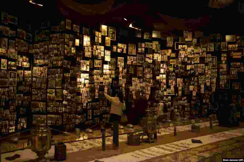 A family looks at photographs of fallen soldiers from World War II on display in a museum in Kyiv.