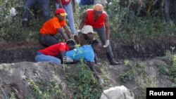 Волонтери го извлекуваат телото на неидентификувано лице од депонија во Најроби, Кенија, на 12 јули 2024 година.