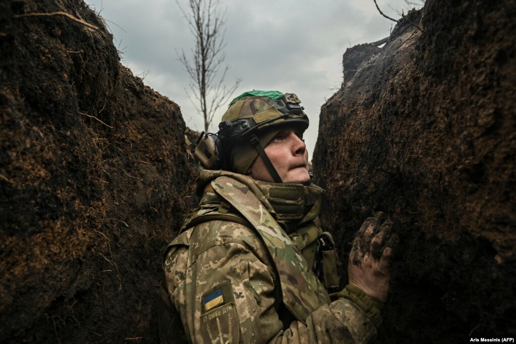 Un soldato ucraino si nasconde in una trincea durante i bombardamenti vicino alla città di Bakhmut.  8 marzo 2023 