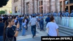 Police officers protecting the parliament faced away from protesters in Yerevan on June 13.