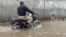 Pakistanski policajac vozi motocikl preko poplavljene ulice u Lahoru 19. avgusta.<br />
<br />
Najmanje 14 ljudi poginulo je u poslednja 24 sata, pošto su poplave izazvane monsunskim kišama izazivale pustoš u delovima Pakistana, rekao je 19. avgusta zvaničnik pokrajinske uprave za upravljanje katastrofama.
