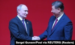 Președintele chinez Xi Jinping (dreapta) și liderul rus Vladimir Putin, la Beijing, în luna mai a acestui an.