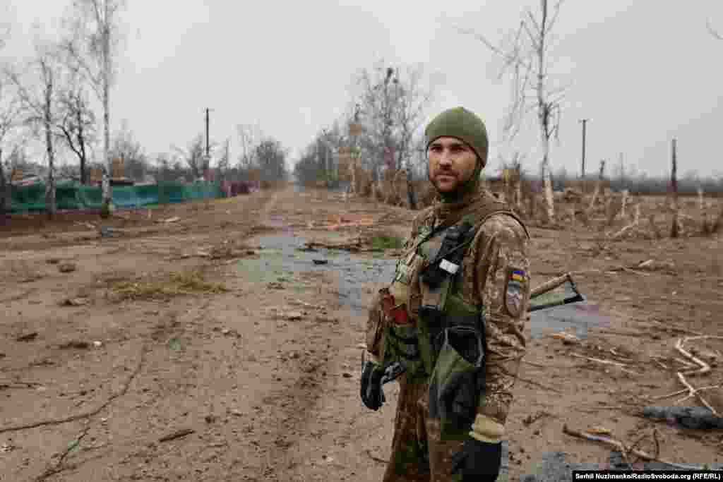 Az első képen egy ukrán katona láthathó a Kijevtől északnyugatra fekvő Teterivszke faluban 2022 márciusában. A második képen ugyanez az útszakasz 2024 márciusában.&nbsp; A galériában található összes, két évvel ezelőtti kép Teterivszkéről 2022 márciusban&nbsp;készült, amikor az orosz és ukrán csapatok között harcok folytak a falu környékén.&nbsp;A 2024-es képek március végén készültek&nbsp;