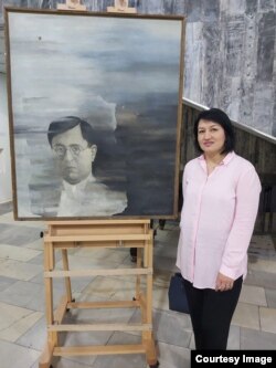 Dilbar Gaffarova from the YUZUK cultural foundation stands with Vyacheslav Akhunov’s portrait of Chulpon in March 2023.