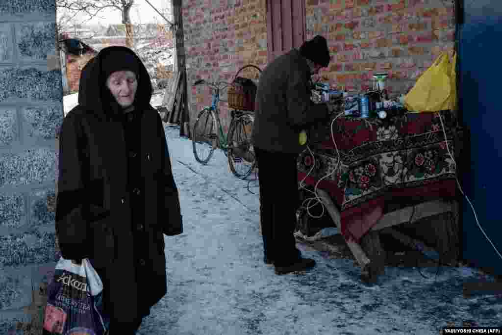 People charge their batteries and mobile phones using power from a generator offered by the city in Siversk, Ukraine.