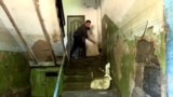 A man removes mud from a stairwell in the hard-hit town of Alaverdi&nbsp;on May 28 as cleanup work continues in northeastern Armenia following the worst flooding in decades.