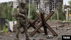 A soldier with the private mercenary company Wagner patrols the streets of Bakhmut. 