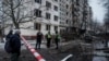 Ukrainian police officers at the scene of a Russian missile strike, which damaged an apartment building in Kyiv on December 13. 