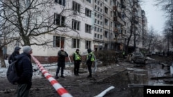 Ukrainian police officers at the scene of a Russian missile strike, which damaged an apartment building in Kyiv on December 13. 