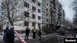 Zyrtarët ukrainas në vendin e ngjarjes së një sulmi raketor rus, i cili e dëmtoi një ndërtesë banimi në Kiev, 13 dhjetor 2023.