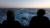 Spašeni migranti gledaju u more sa spasilačkog broda Geo Barents na putu ka italijanskoj luci Bari, Sredozemno more, 25. mart 2023.