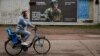 A local resident cycles by a recruitment advert for the Ukrainian Army in the Dnipropetrovsk region (file photo)