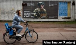 A local resident rides a bike near a recruitment advert for the Ukrainian Army in the Dnipropetrovsk region. (file photo)