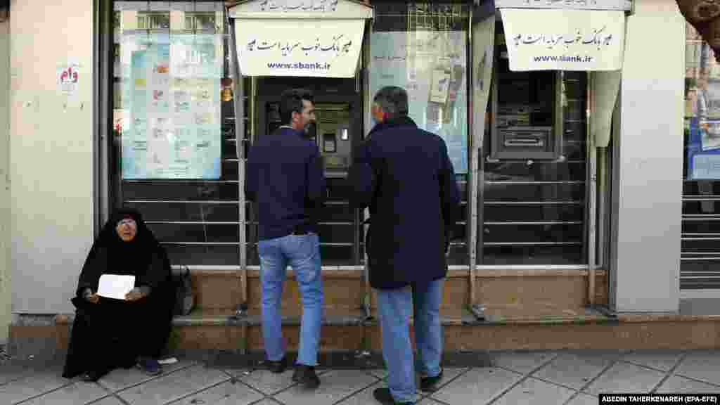 Iranci koriste bankomat na ulici u centru Teherana. Iran se suočava s ekonomskom krizom nakon što je njegova valuta prošle sedmice pala na najnižu vrijednost u odnosu na američki dolar i druge strane valute, nakon sankcija koje su uvele Sjedinjene Države i EU.